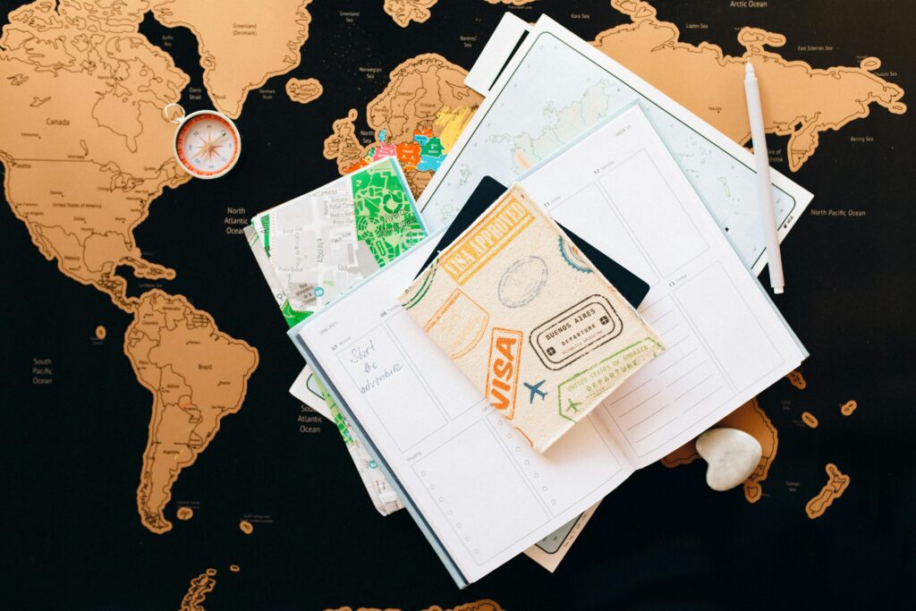 A worldmap with papers on it and a passport. 