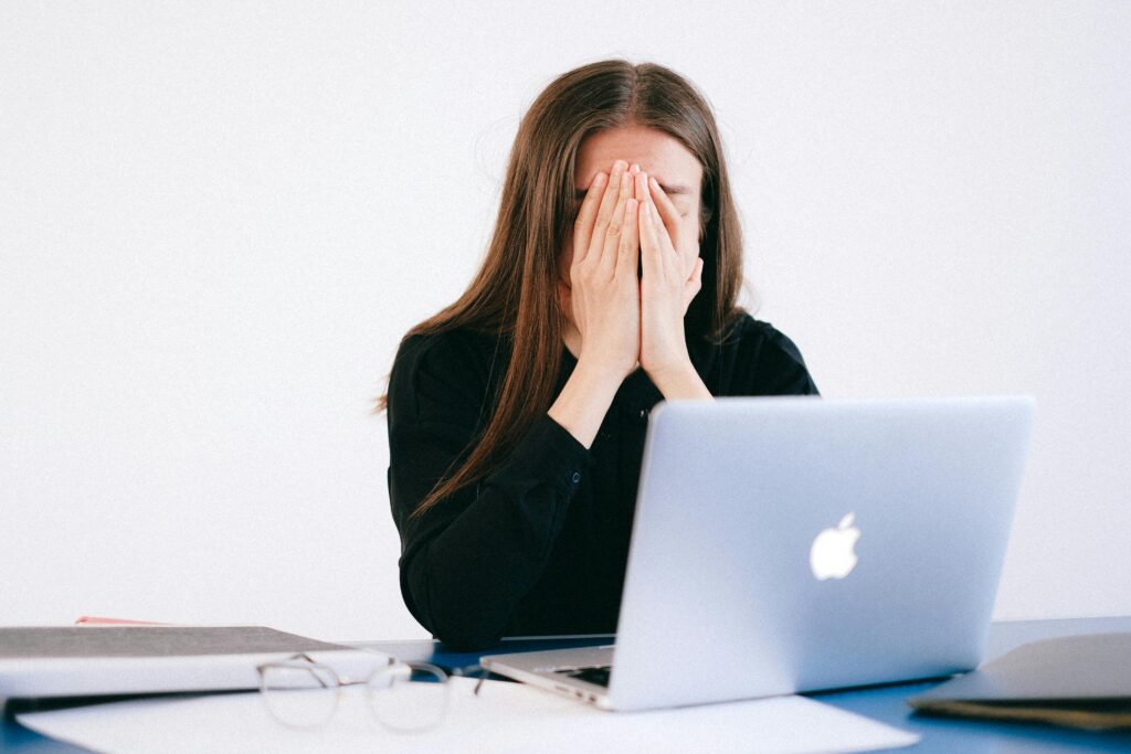 A woman who is stressed sitting behind a desk.
