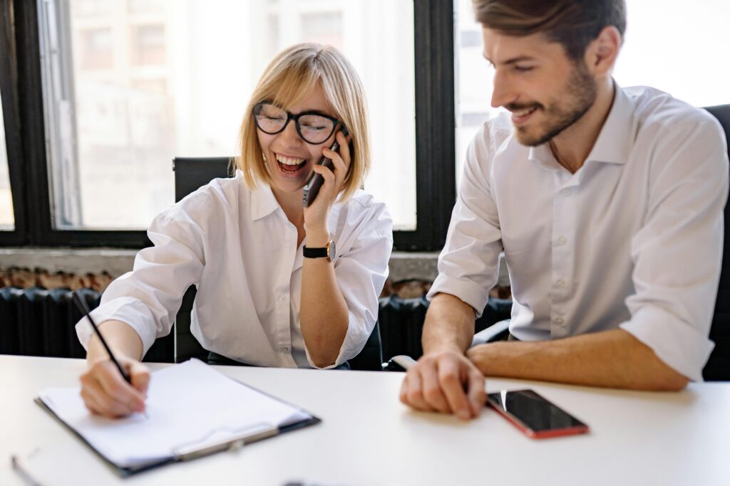 Two co-workers working at a happy office.